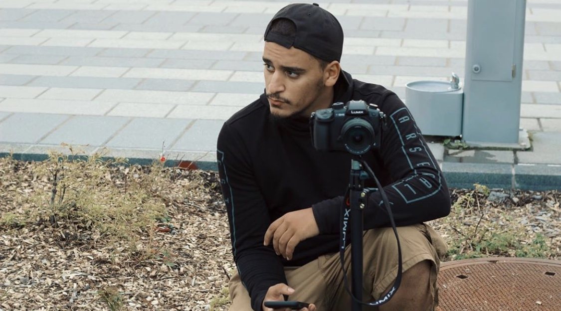 Wolf crouched beside his camera, watching the scene