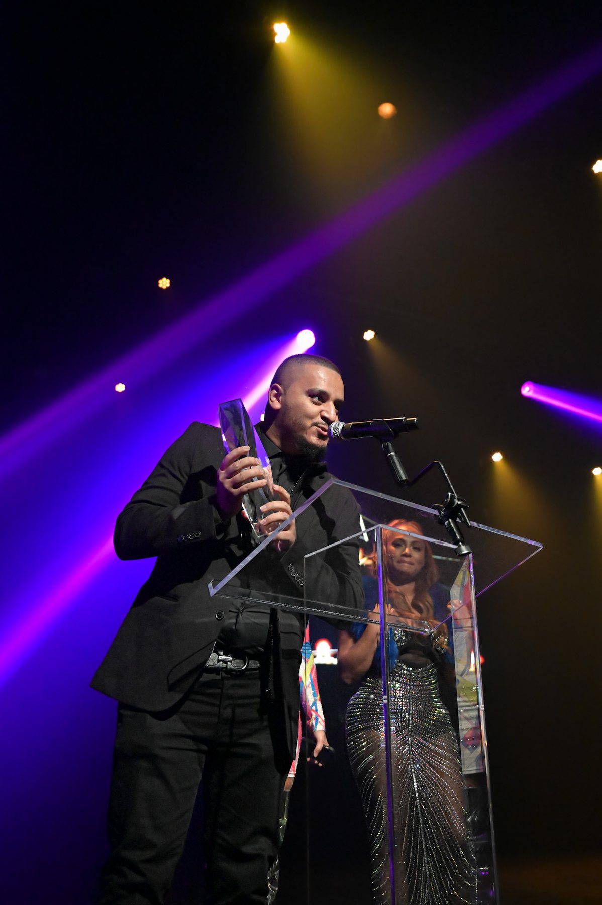 Wolf on stage at an award night, trophy in hand