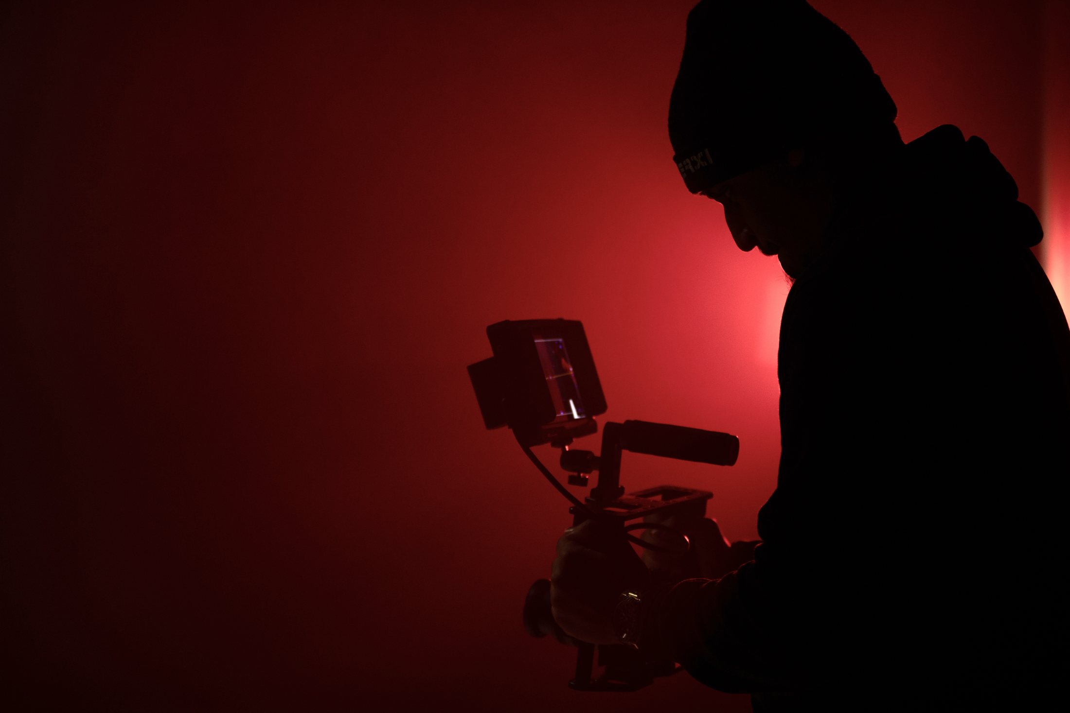 Wolf's silhouette with his camera rig against deep red light