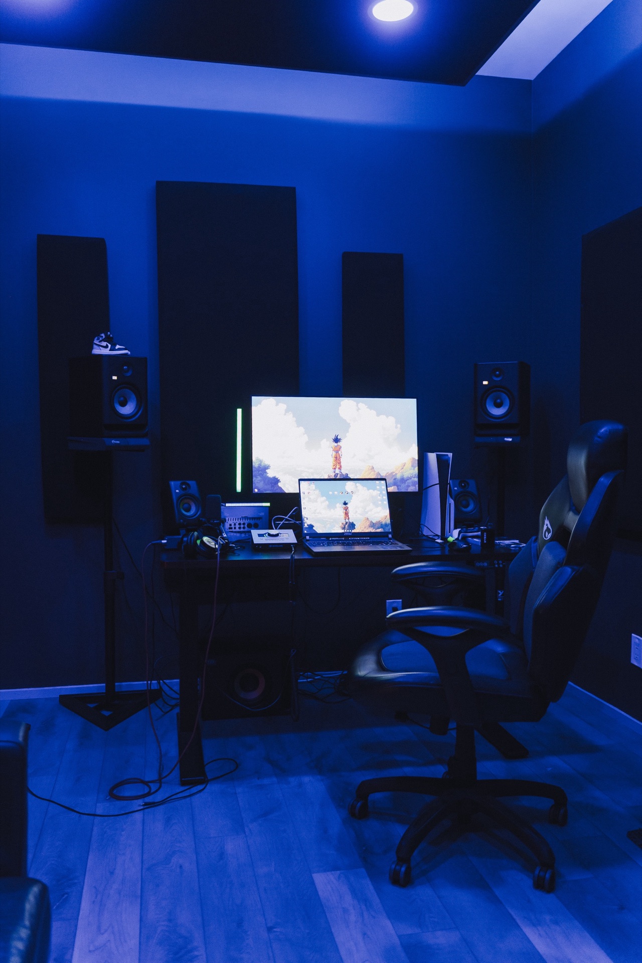 The full studio room — monitors, acoustic panels, blue ambient